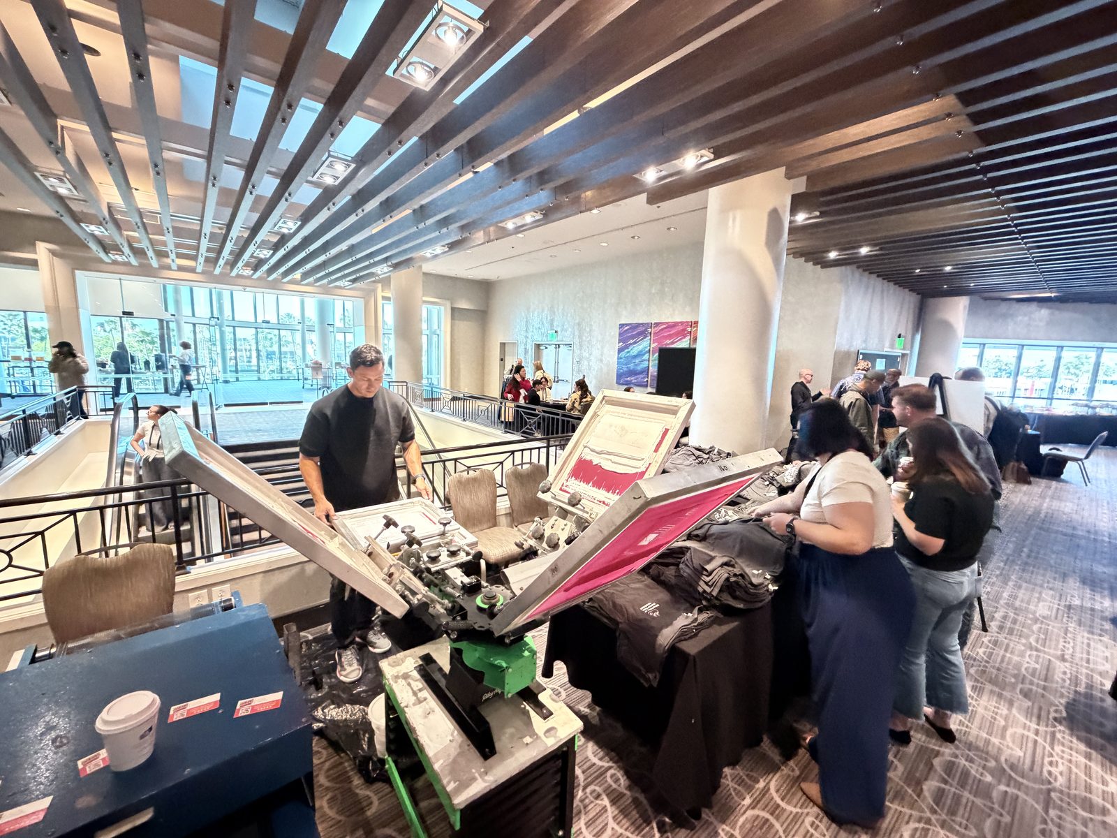 Guests watching a printer pull a squeegee at a Los Angeles event
